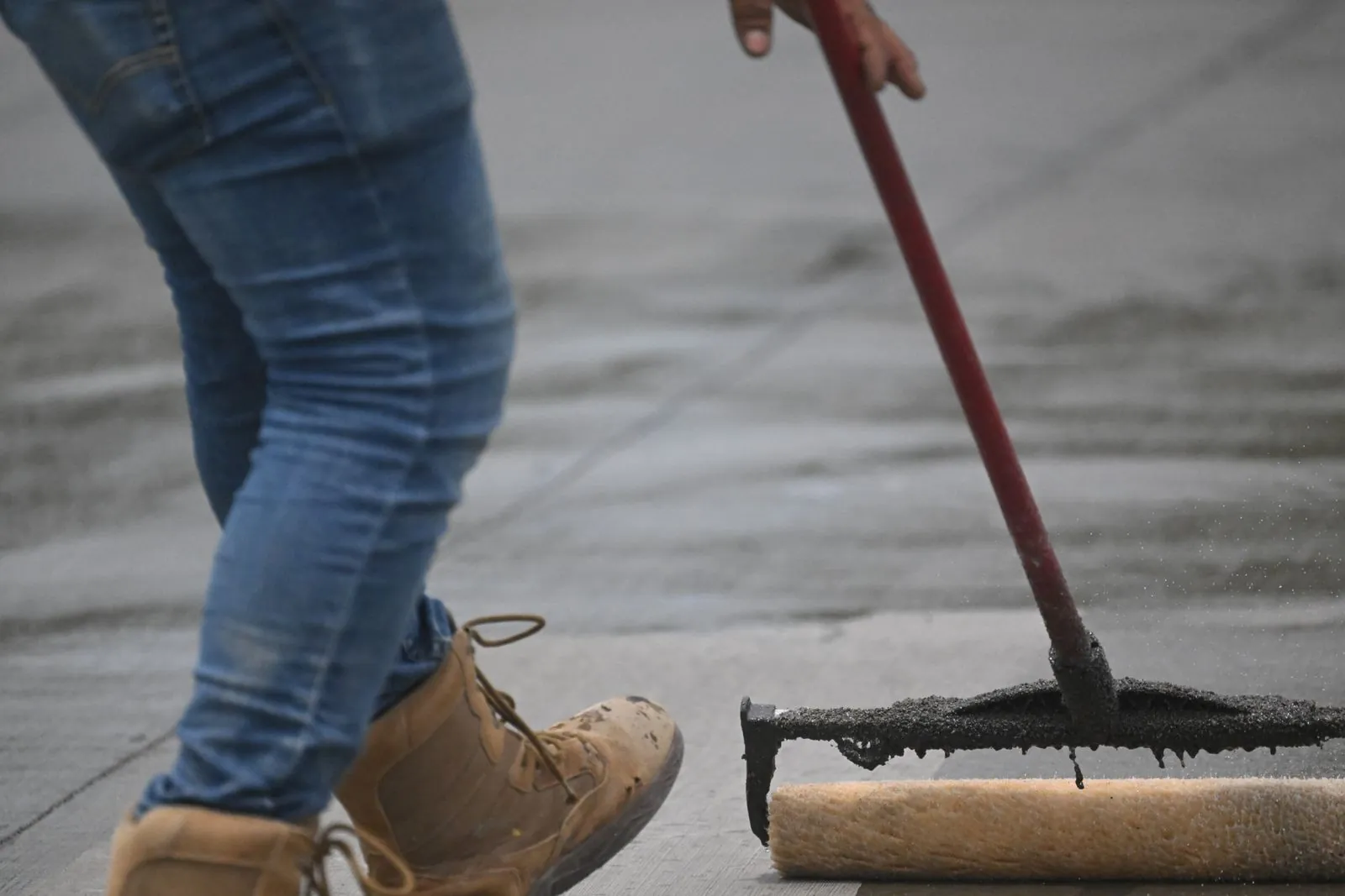 Applying a fresh sealer overlay coat to an existing concrete surface by Ortiz Concrete Services